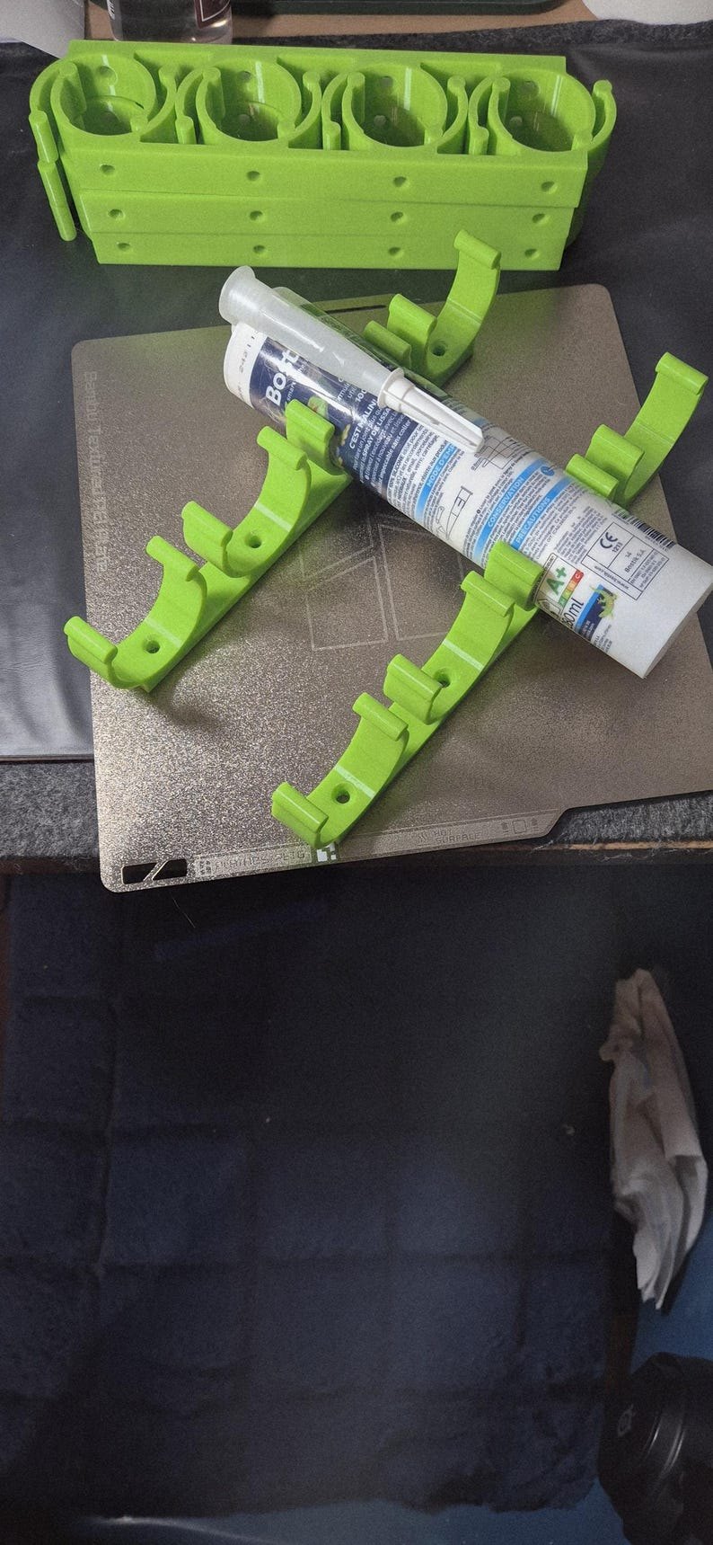 Supports de cartouches en PETG vert à la sortie de l’imprimante 3D